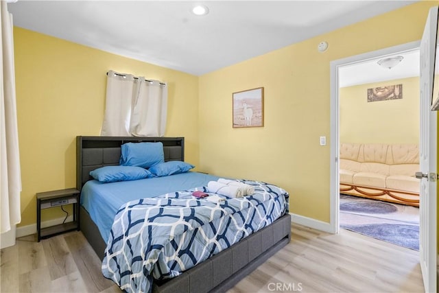 bedroom featuring light wood finished floors and baseboards