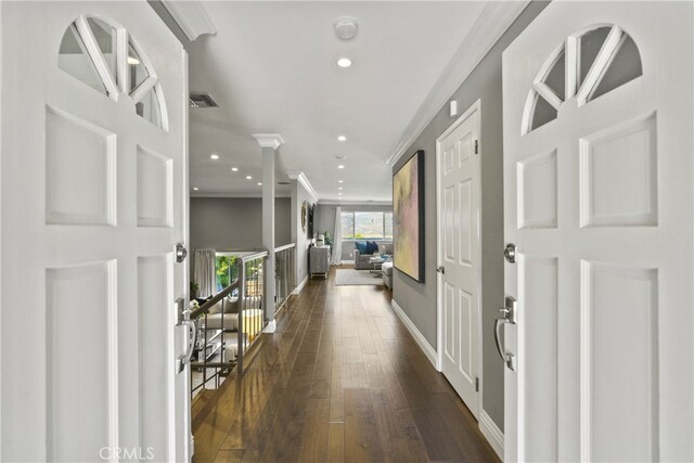 hall featuring dark wood-style flooring, recessed lighting, visible vents, ornamental molding, and baseboards