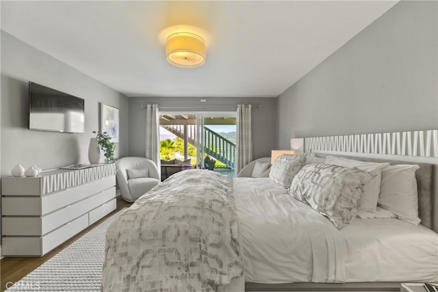 bedroom with access to exterior and dark wood-style flooring