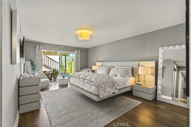 bedroom featuring baseboards, dark wood-style flooring, visible vents, and access to exterior