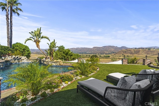 view of yard featuring an outdoor pool and a mountain view