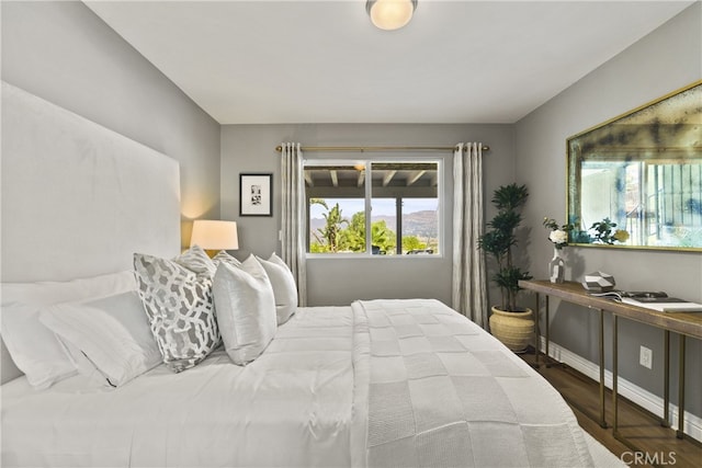 bedroom featuring baseboards and wood finished floors