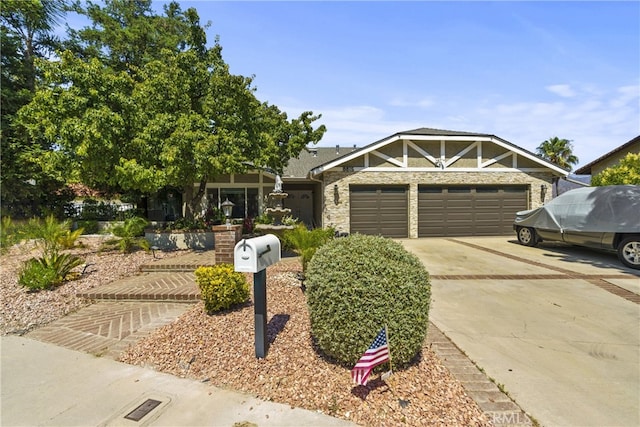 craftsman-style home featuring a garage, concrete driveway, and stone siding