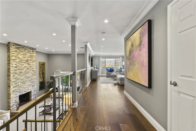 hallway with ornamental molding, wood finished floors, decorative columns, and baseboards