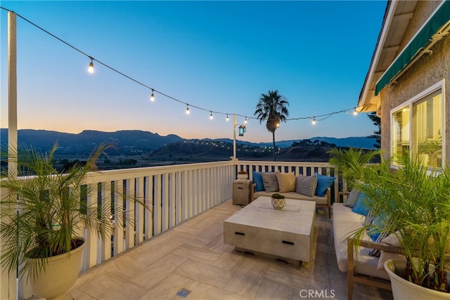 patio terrace at dusk featuring a mountain view and an outdoor living space