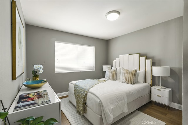 bedroom with wood finished floors and baseboards