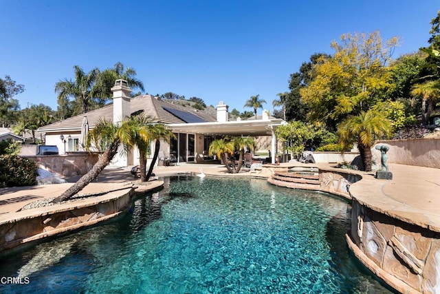 pool with a patio and a jacuzzi