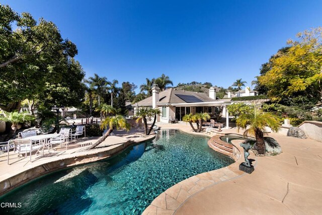 pool featuring an in ground hot tub and a patio area