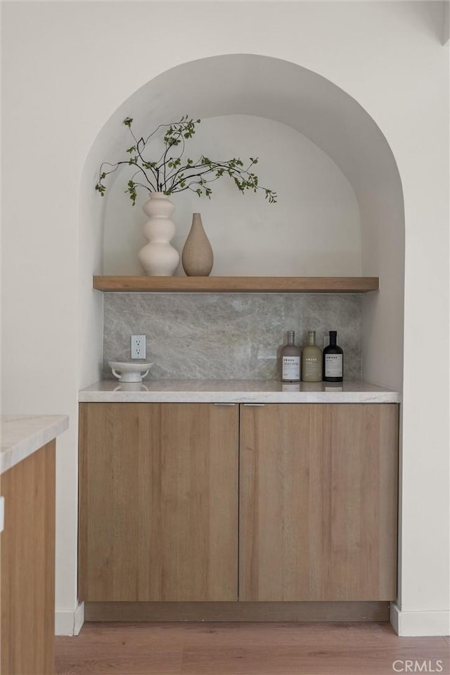 bar with light wood-style flooring and baseboards