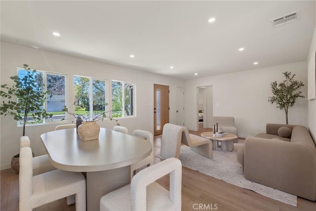 dining area with baseboards, light wood-type flooring, visible vents, and recessed lighting