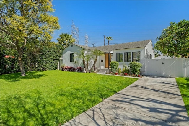 ranch-style home featuring concrete driveway, a front lawn, a gate, and stucco siding