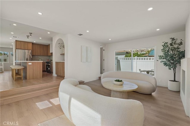 living area with light wood-type flooring, recessed lighting, and visible vents