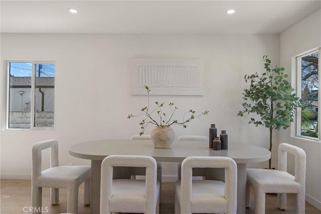 dining space with a healthy amount of sunlight, wood finished floors, and recessed lighting