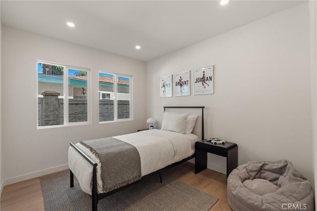 bedroom with baseboards, light wood-type flooring, and recessed lighting