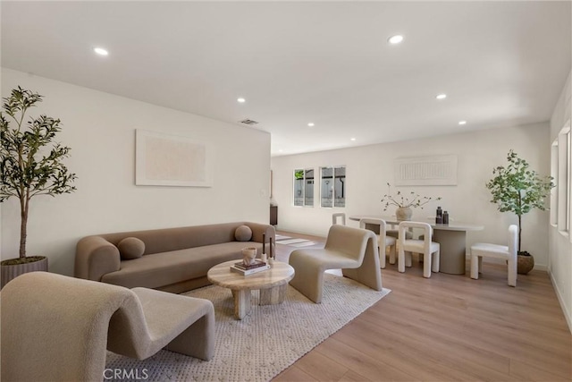 living area with visible vents, light wood-style flooring, and recessed lighting