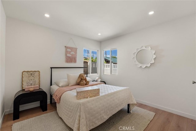 bedroom featuring baseboards, wood finished floors, and recessed lighting