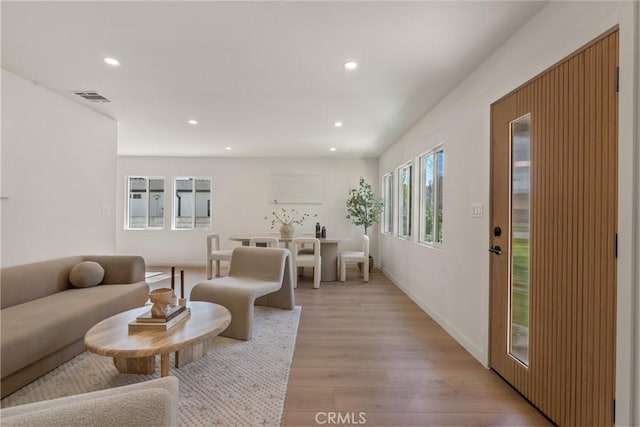 living area featuring light wood-style floors, baseboards, visible vents, and recessed lighting