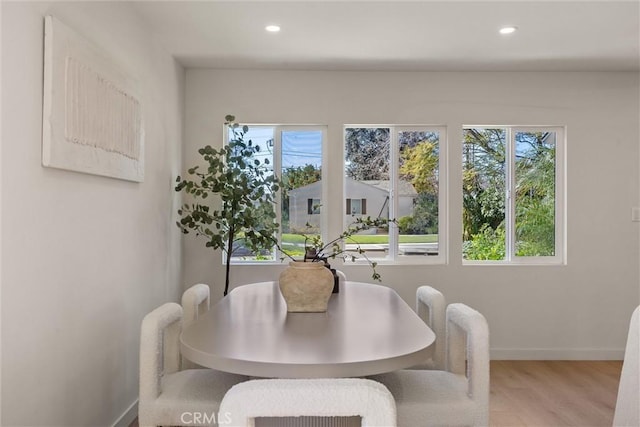 dining space featuring plenty of natural light, baseboards, wood finished floors, and recessed lighting