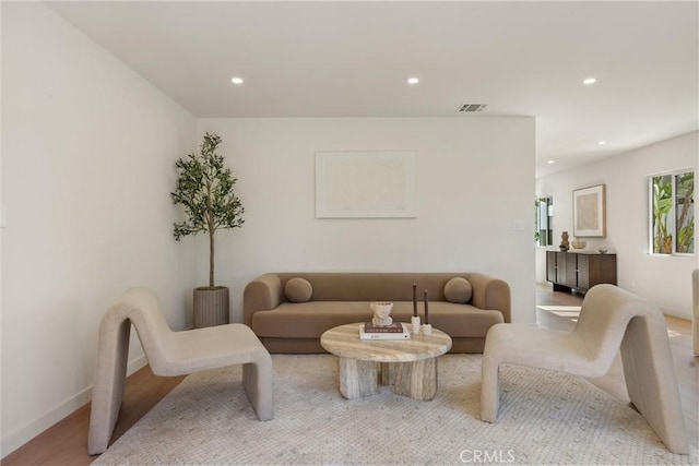 living area with visible vents, wood finished floors, and recessed lighting