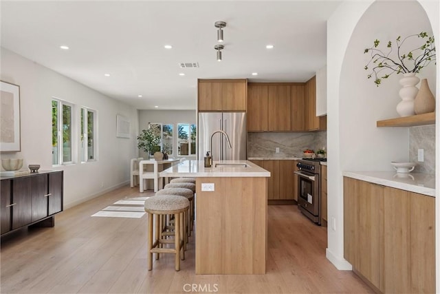 kitchen with stainless steel appliances, a wealth of natural light, visible vents, and a sink