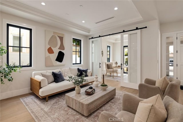 1820 9th St, Manhattan Beach, CA 90266 - living room with a barn door, light wood-style flooring, a tray ceiling, and crown molding