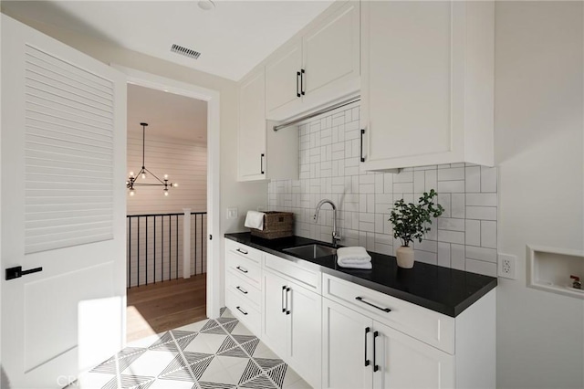 1820 9th St, Manhattan Beach, CA 90266 - kitchen with a sink, decorative backsplash, dark countertops, and a chandelier