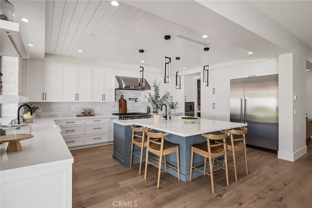 1820 9th St, Manhattan Beach, CA 90266 - kitchen featuring wall chimney range hood, stainless steel built in fridge, light wood-style floors, and a sink