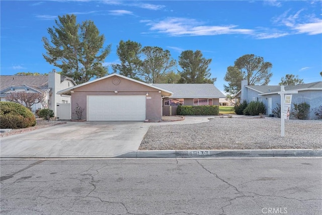 ranch-style house with concrete driveway, a garage, and stucco siding