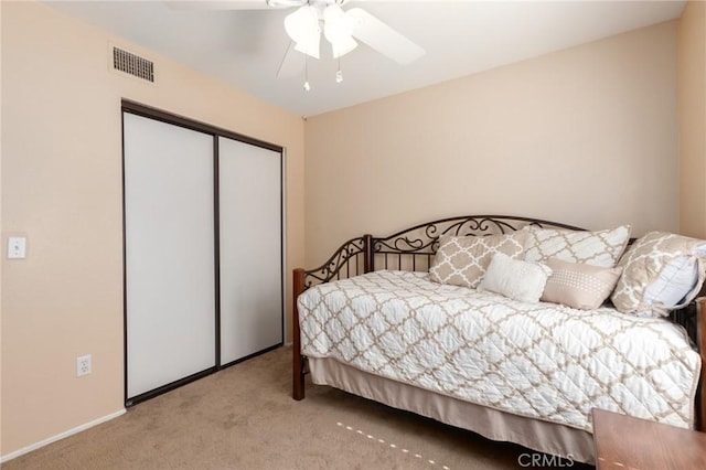 bedroom with carpet floors, a closet, visible vents, and a ceiling fan