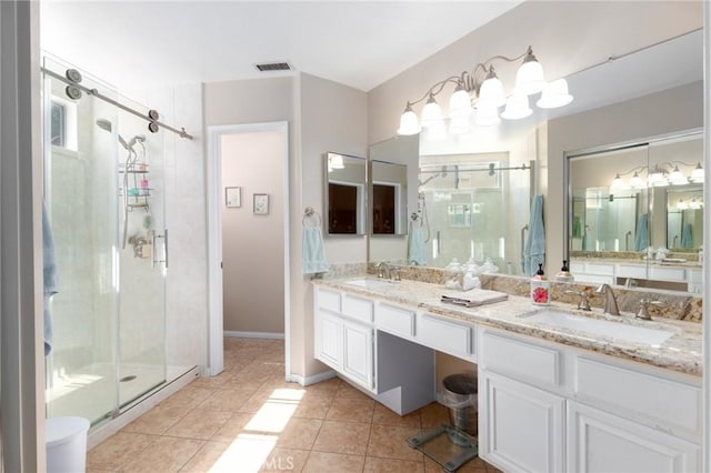 bathroom featuring a sink, visible vents, tile patterned floors, double vanity, and a stall shower