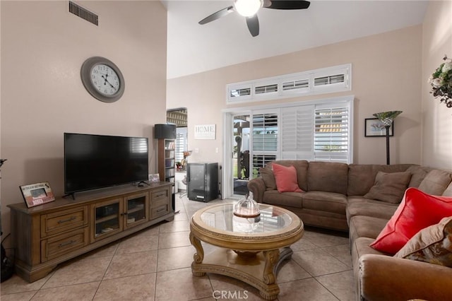 living area featuring a high ceiling, visible vents, a ceiling fan, and light tile patterned flooring