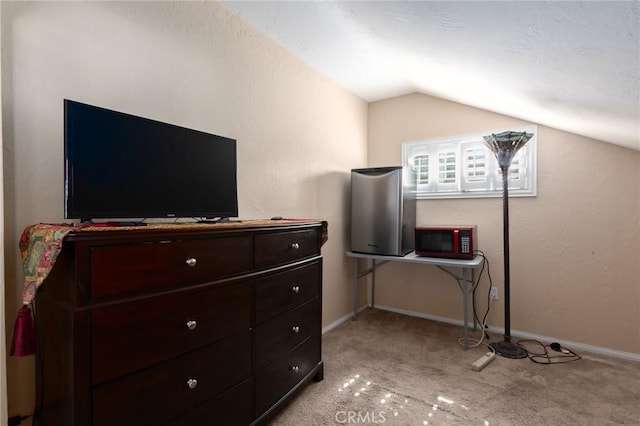 bedroom featuring lofted ceiling, light carpet, and baseboards