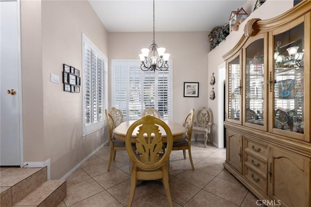 dining room with a wealth of natural light, light tile patterned floors, baseboards, and a notable chandelier