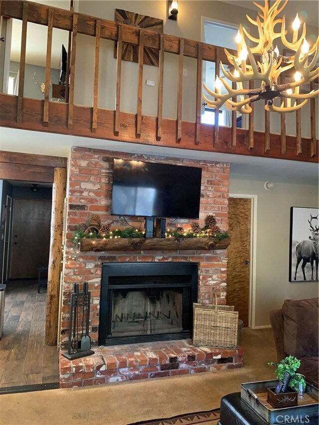 33492 Wild Rose Dr, Green Valley Lake, CA 92341 - living room with a towering ceiling, an inviting chandelier, a fireplace, and wood finished floors