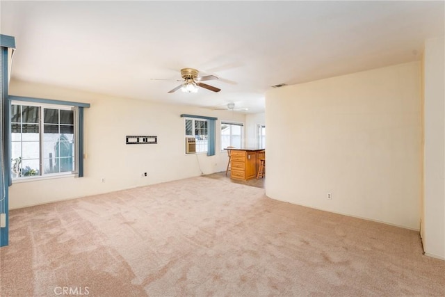 empty room featuring light carpet, visible vents, and a ceiling fan