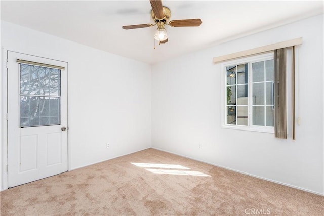 carpeted empty room with a ceiling fan