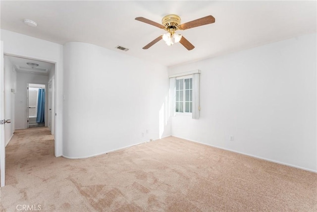 empty room featuring carpet, visible vents, and ceiling fan