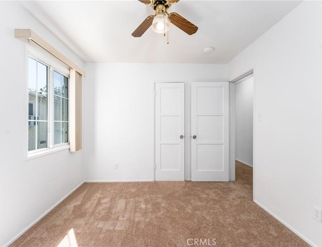 unfurnished bedroom featuring ceiling fan, carpet floors, and a closet