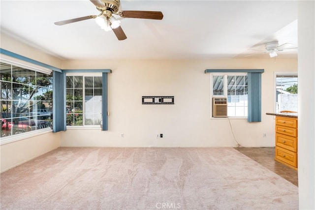 carpeted spare room featuring ceiling fan and cooling unit