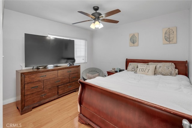 bedroom with ceiling fan, light wood-type flooring, and baseboards