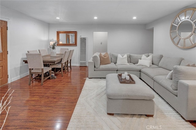 living area with baseboards, wood finished floors, and recessed lighting