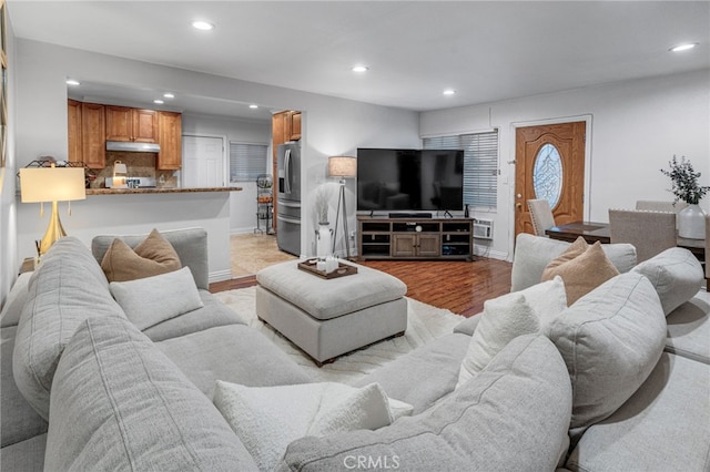 living room with light wood-type flooring, baseboards, and recessed lighting