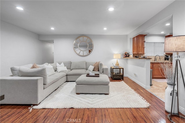 living area featuring recessed lighting, baseboards, and wood finished floors