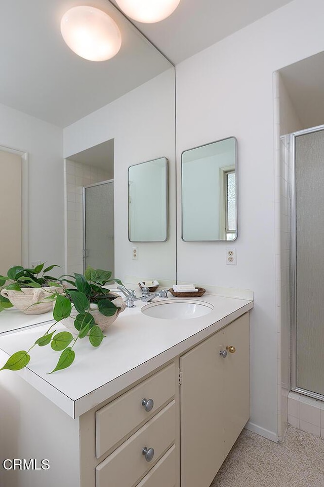 bathroom featuring a shower stall and vanity