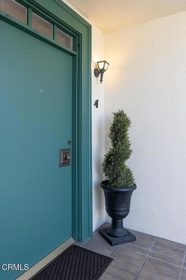 doorway to property featuring stucco siding