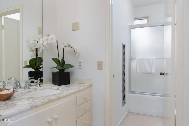 bathroom featuring enclosed tub / shower combo and vanity