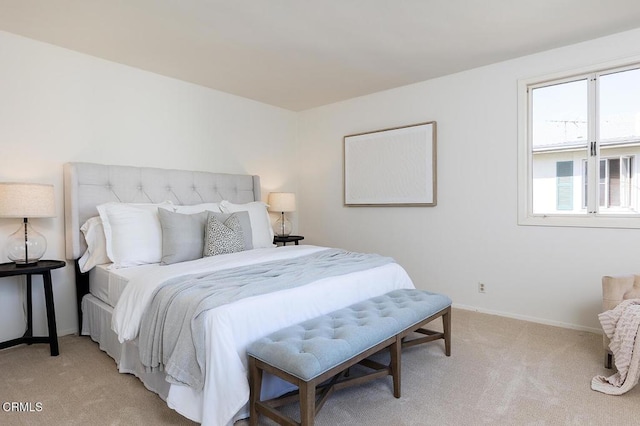 bedroom with baseboards and light colored carpet