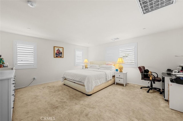 bedroom with baseboards, visible vents, and light colored carpet