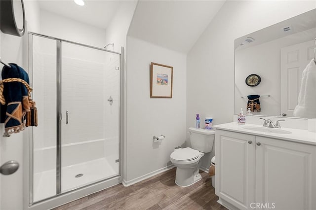 bathroom with visible vents, wood finished floors, a shower stall, and vanity