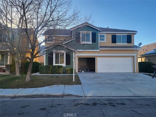 traditional-style home with a garage, driveway, and stucco siding